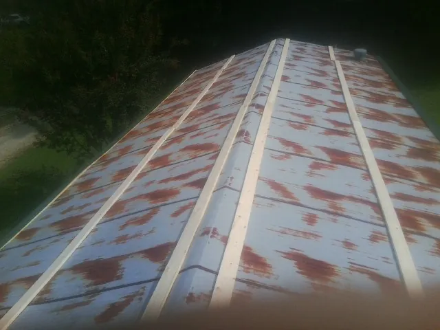 Rusted metal roof panels with new wood purlins before replacement — Storm Damage Roof Repair in Balko by Roofing Brothers