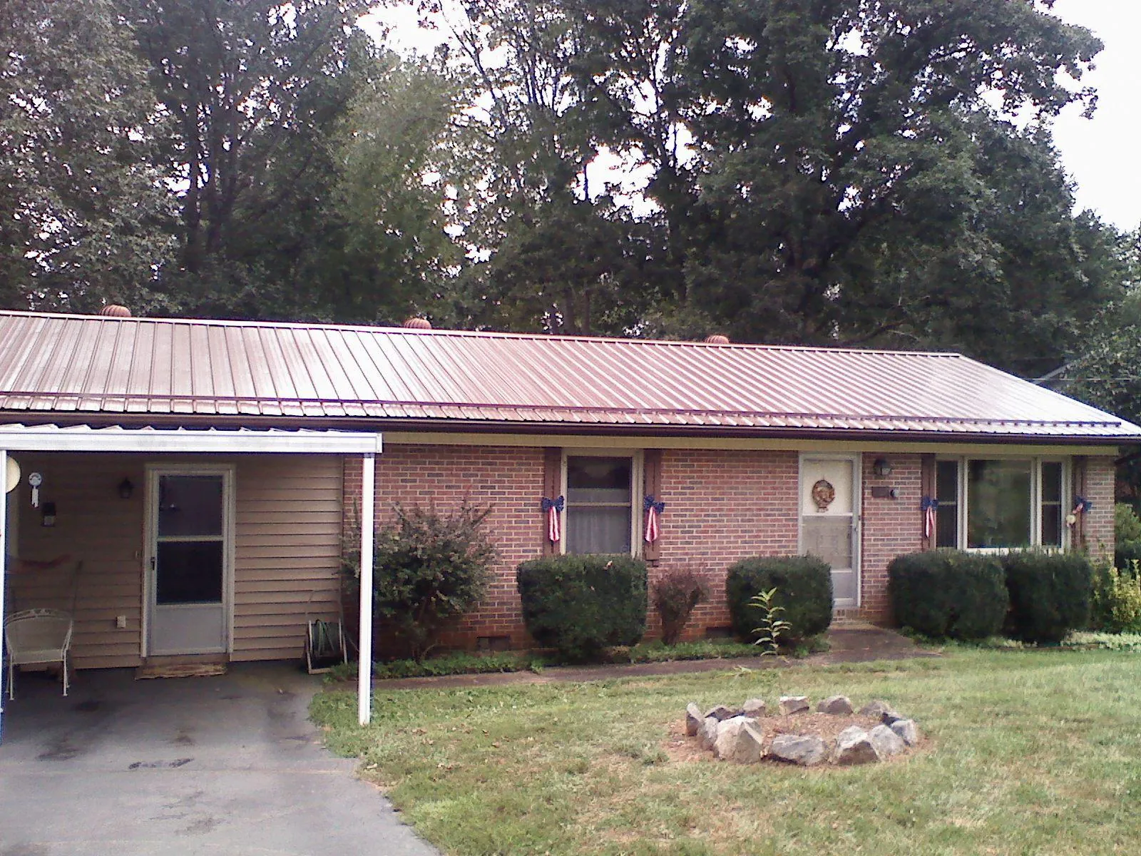Bronze metal roof and carport on a brick ranch home — Roof Repair work by our crew in Balko
