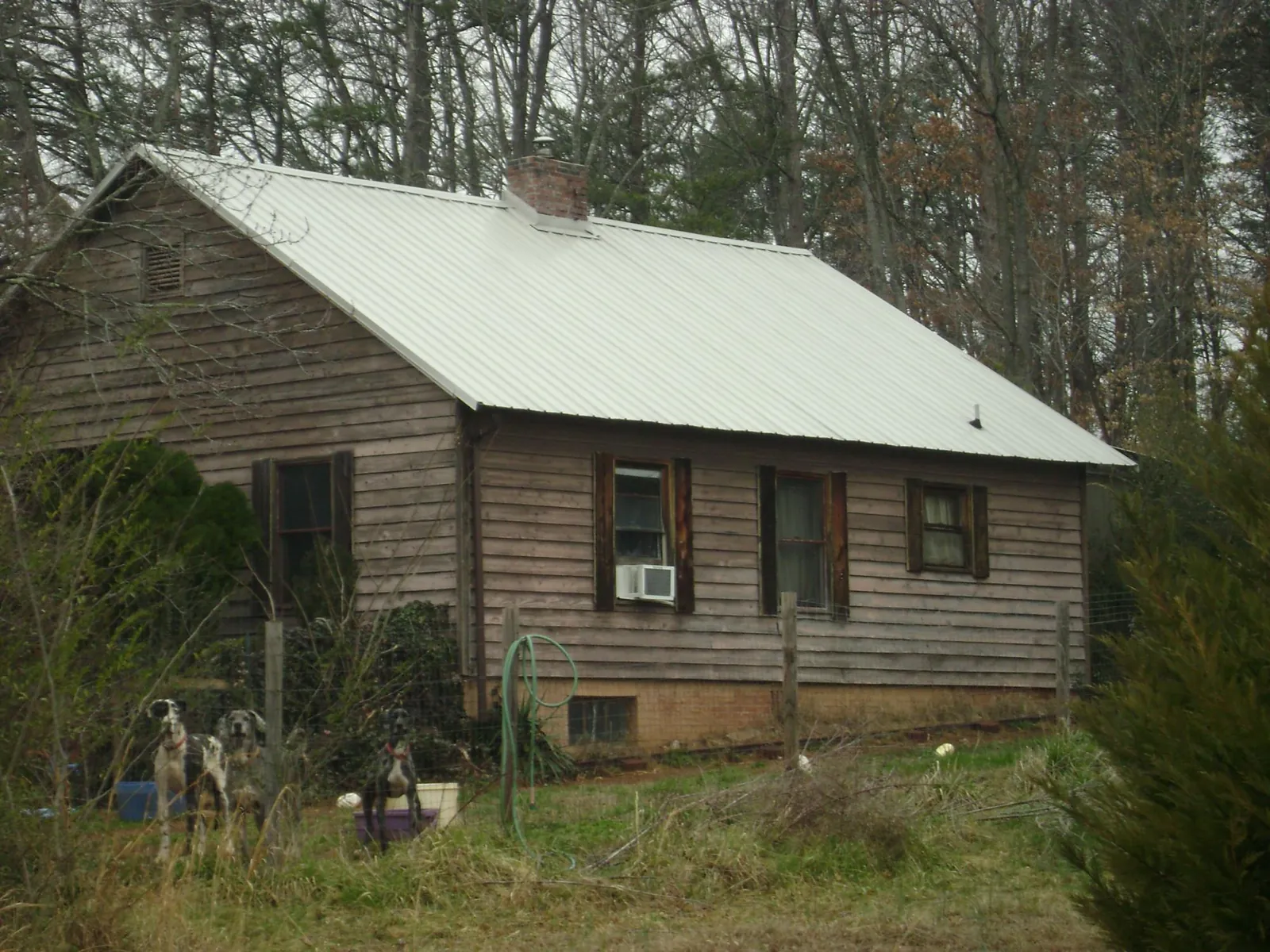 White metal roof on an old wood sided farmhouse, from a Metal Roof Installation job in Balko